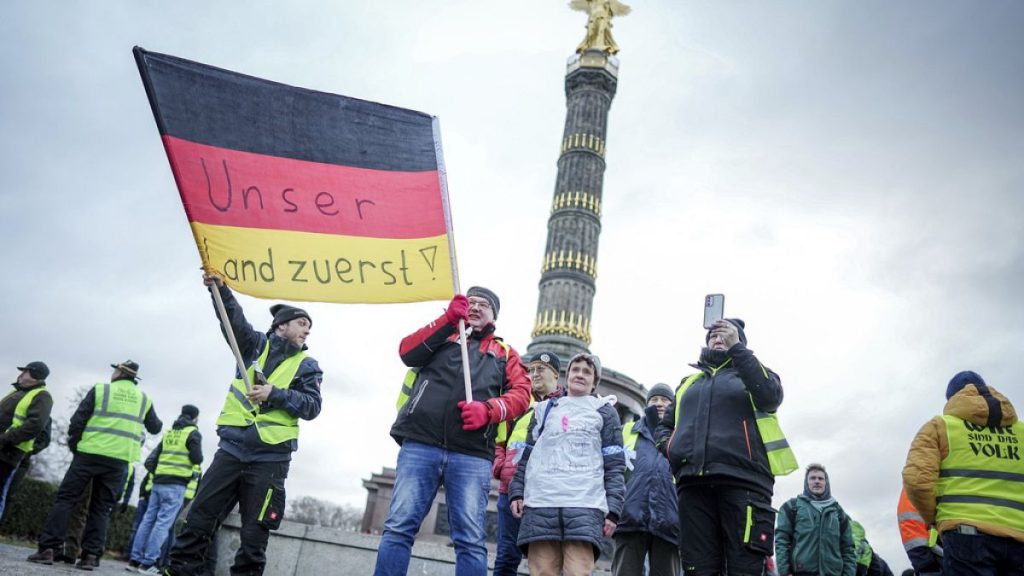 Farmers hold up a flag with writing in German reading