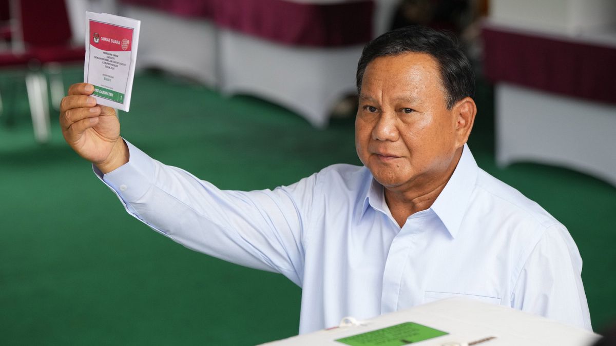 Indonesian presidential candidate Prabowo Subianto shows a ballot during the election in Bojong Koneng, Indonesia, Wednesday, Feb. 14, 2024.