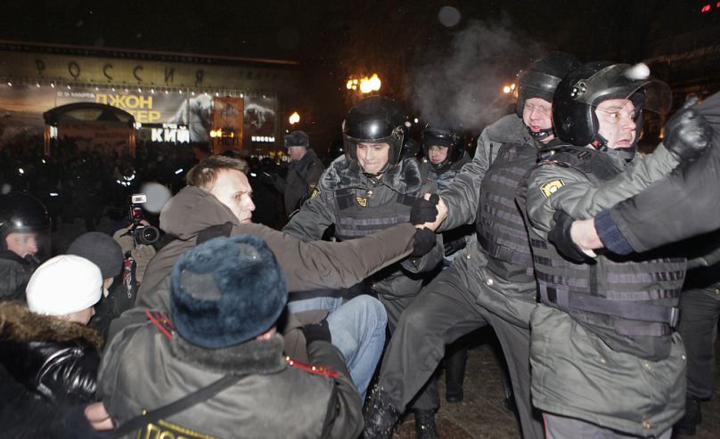 DOSSIER – La police arrête le leader de la protestation Alexei Navalny, vu portant une veste à capuche, après un rassemblement sur la place Pouchkine à Moscou, le lundi 5 mars 2012.