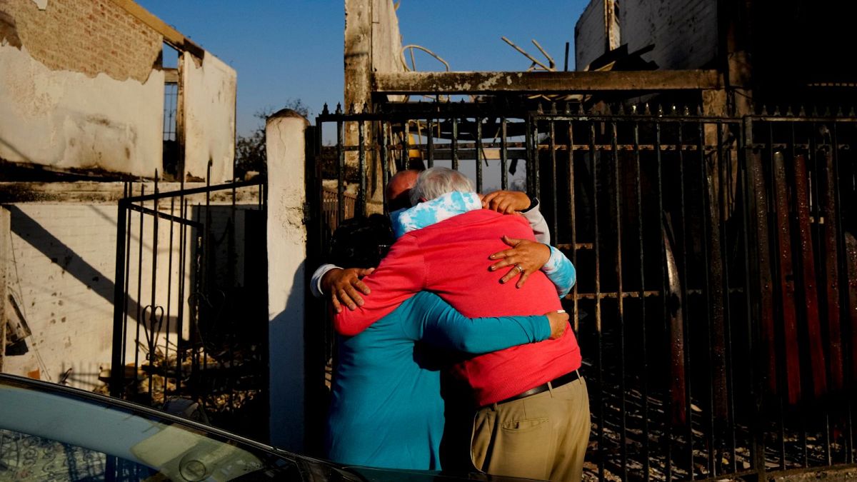 Residents embrace each other after a forest fire - made deadlier by climate change - reached their neighbourhood in Vina del Mar, Chile, 3 February 2024.