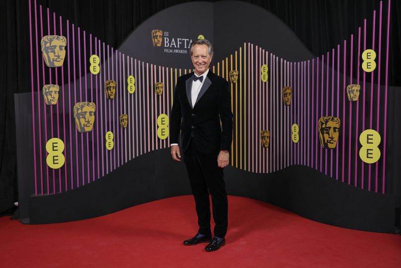 Richard E Grant pose pour les photographes à son arrivée à la 77e cérémonie des British Academy Film Awards, BAFTA 2024