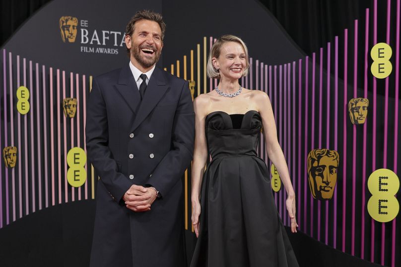 Bradley Cooper, à gauche, et Carey Mulligan posent pour les photographes à leur arrivée au 77e British Academy film Awards, BAFTA's, à Londres.