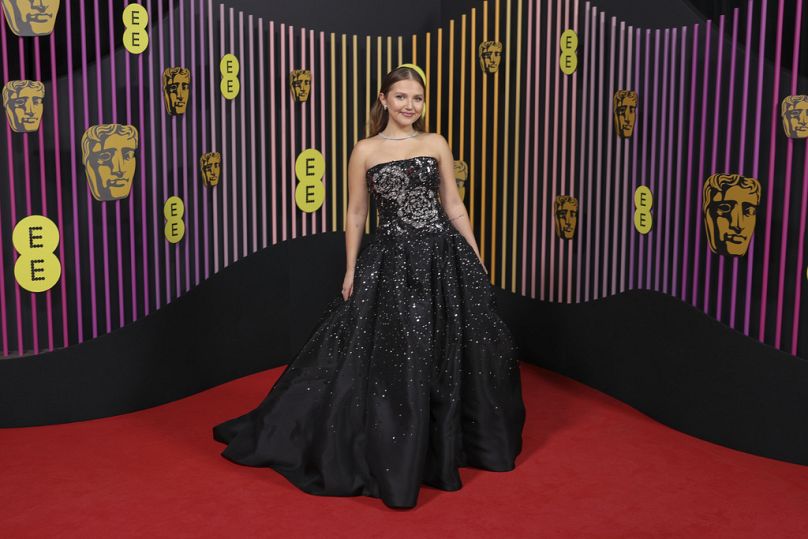 Mia McKenna-Bruce pose pour les photographes à son arrivée à la 77e cérémonie des British Academy Film Awards, les BAFTA, à Londres