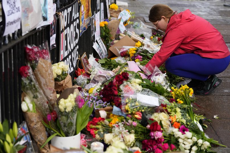 Une femme rend hommage à l'homme politique russe Alexi Navalny, près de l'ambassade de Russie à Londres, le dimanche 18 février 2024.