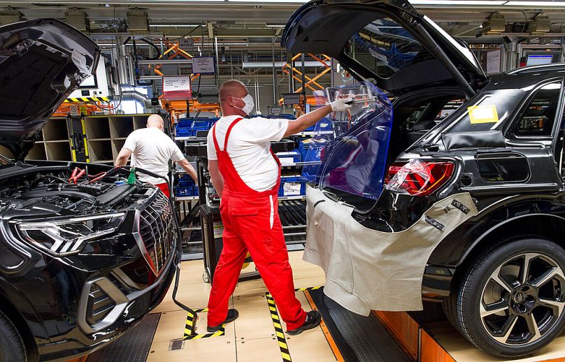 Des ouvriers portant des masques de protection reprennent la production automobile dans l'usine Audi de Gyor, en Hongrie, en avril 2020.