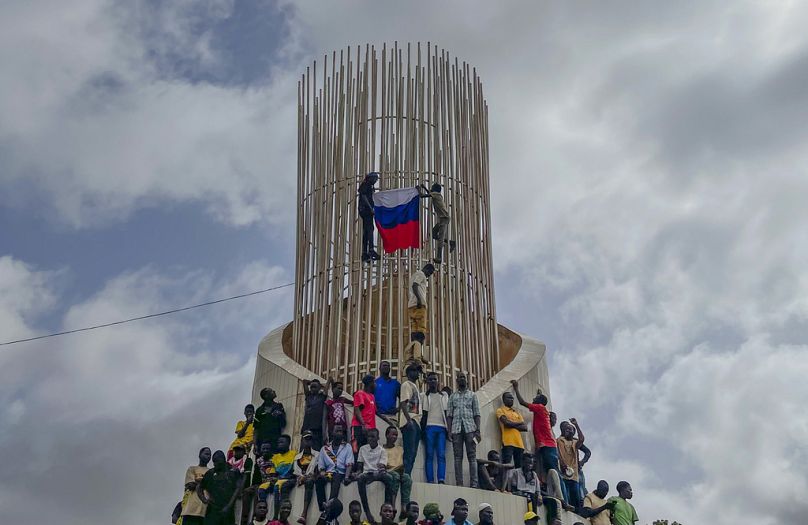 Les partisans de la junte au pouvoir au Niger brandissent un drapeau russe au début d'une manifestation à Niamey, en août 2023.