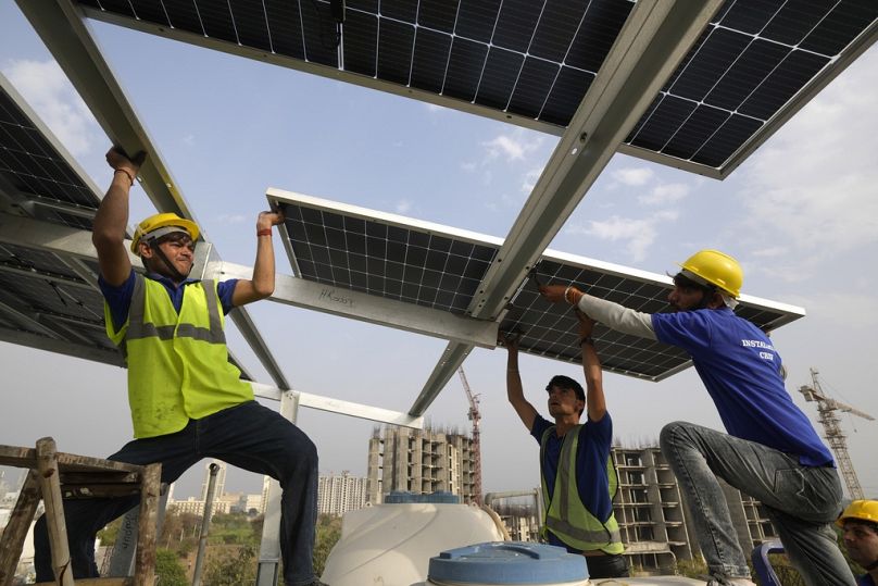 Des ouvriers installent un panneau sur le toit d'une résidence à Gurugram, dans la banlieue de New Delhi, en février 2024.