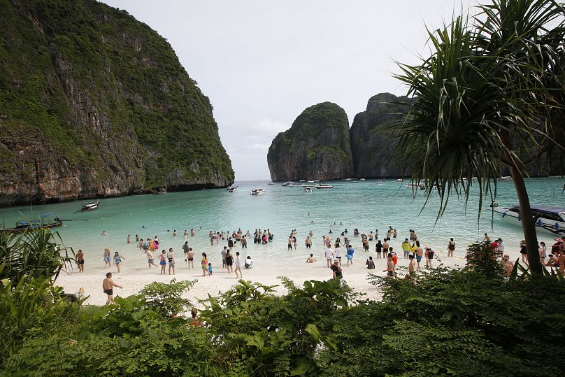 Les touristes se promènent sur la plage de Maya Bay, sur l'île de Phi Phi Leh, dans la province de Krabi, en Thaïlande.