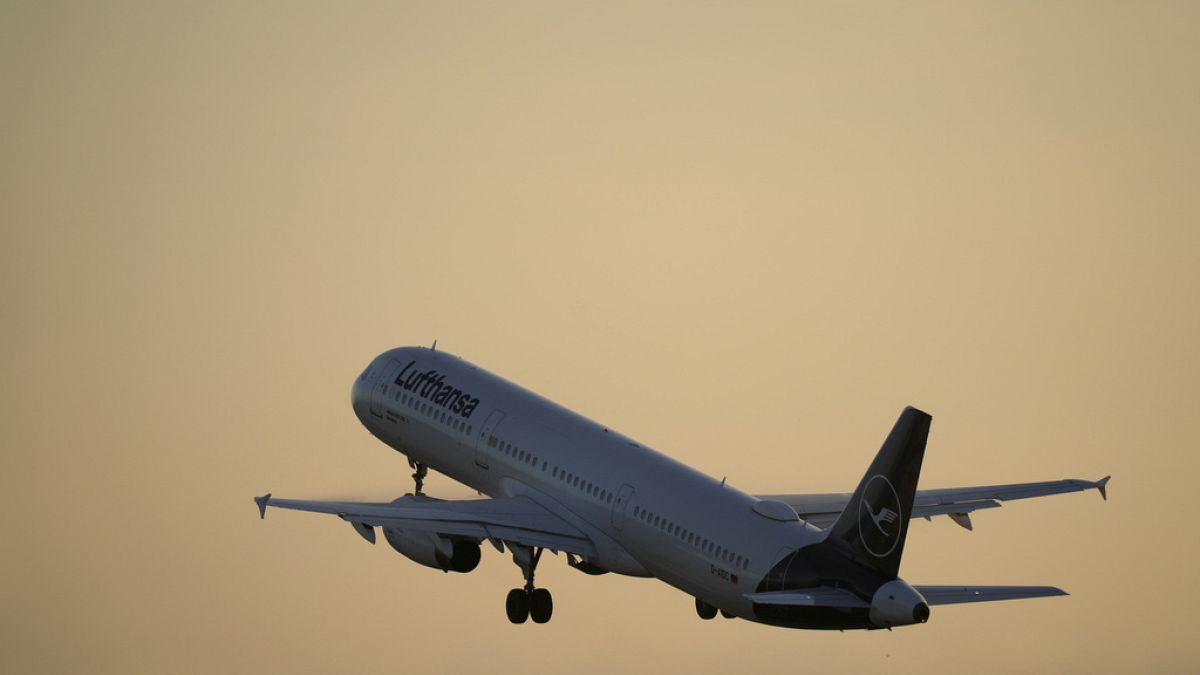 A Lufthansa Airbus A321 takes off from Lisbon at sunrise