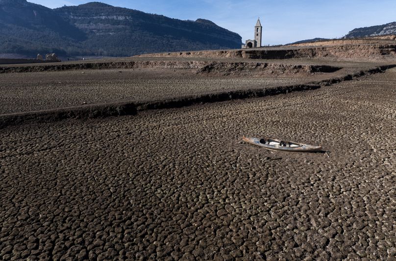 Un kayak abandonné repose sur le sol fissuré du réservoir de Sau, au nord de Barcelone.