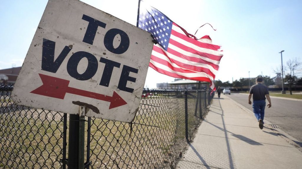 A sign pointing people in the direction of a voting both in the US.