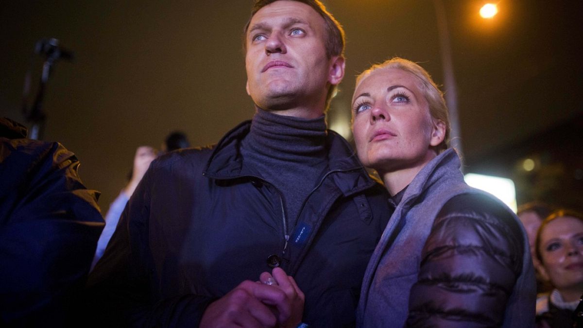 FILE - Russian opposition leader Alexei Navalny, left, and his wife Yulia after a rally in rain-soaked Moscow, Russia, Sept. 6, 2013.