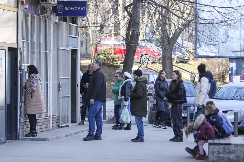 Des gens font la queue devant un distributeur automatique de billets dans la partie nord-serbe de Mitrovica, une ville ethniquement divisée.