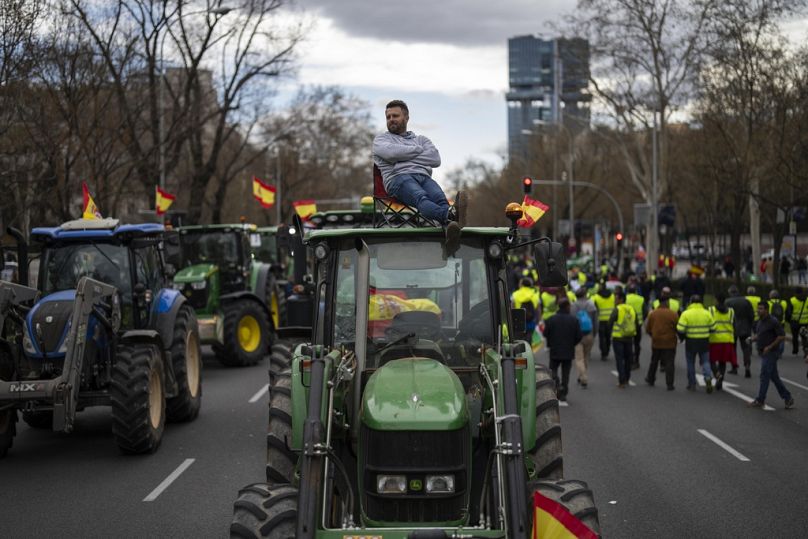 Un agriculteur est assis au sommet d'un tracteur lors d'une manifestation devant les bureaux du Parlement européen à Madrid, en Espagne, le lundi 26 février 2024.