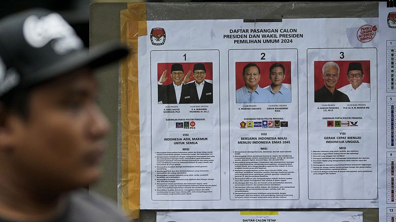 Un homme passe devant une affiche de l’élection présidentielle avec des portraits de candidats à la présidentielle