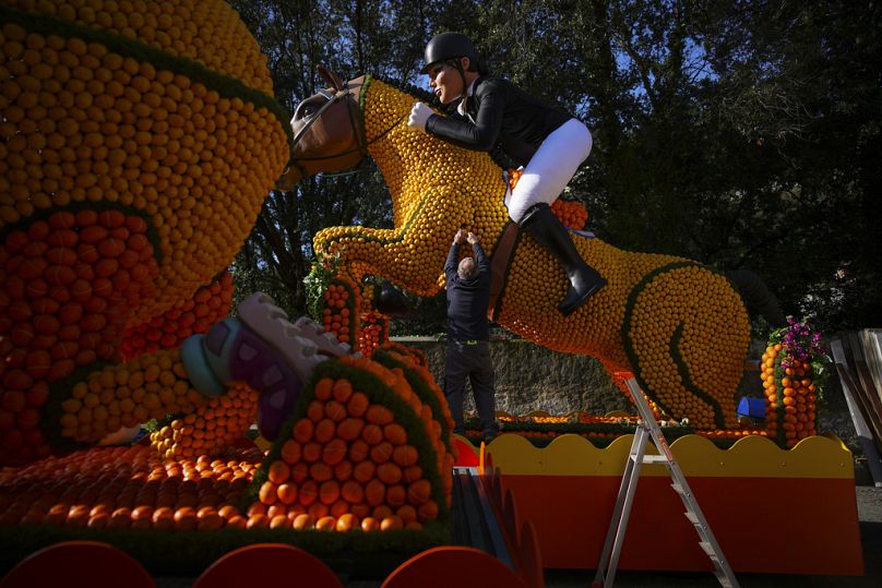 Un ouvrier place des citrons sur un char du carnaval équestre olympique lors de la 90e édition de l'Olympia de Menton de la Fête du Citron à Menton, dans le sud de la France, le 17 février 2024.