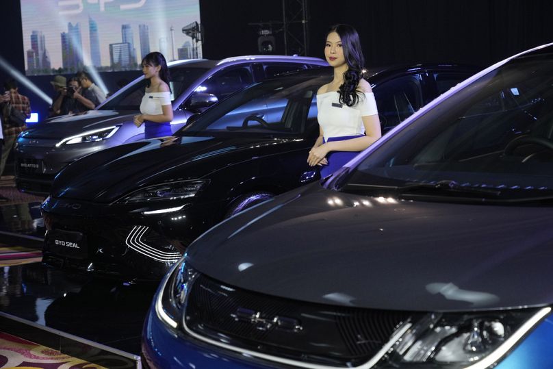 Des modèles se trouvent à proximité des voitures électriques BYD exposées lors de leur événement de lancement à Jakarta, en janvier 2024.