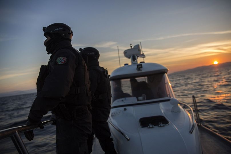 Des membres de la patrouille Frontex alors que le soleil se lève près de l'île grecque de Lesbos, au nord-est de la Grèce, décembre 2015.