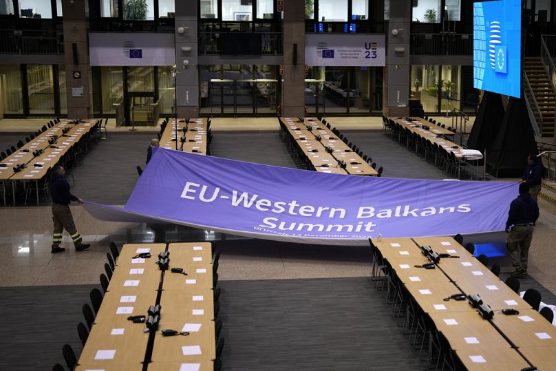 Les travailleurs commencent à installer une banderole dans la salle de presse d'un sommet UE-Balkans occidentaux au bâtiment du Conseil européen à Bruxelles, décembre 2023.