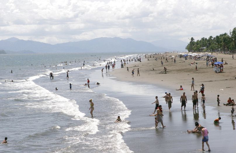 Des touristes jouent dans les vagues dans le port de Puntarenas, sur le Pacifique, au Costa Rica, en octobre 2006.