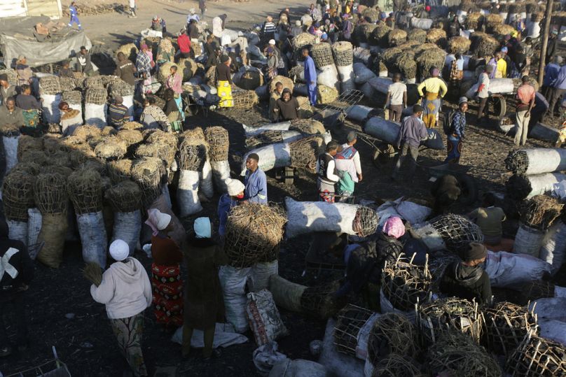 Des gens se rassemblent pour acheter du charbon de bois sur un marché animé de Lusaka, juillet 2021