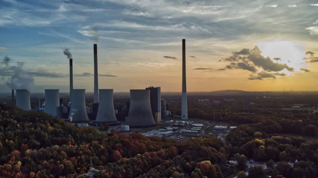 The sun sets behind the cole-fired power plant