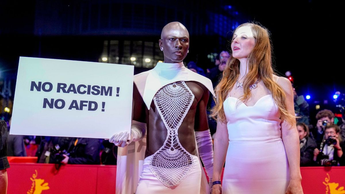 A person holds a sign reading