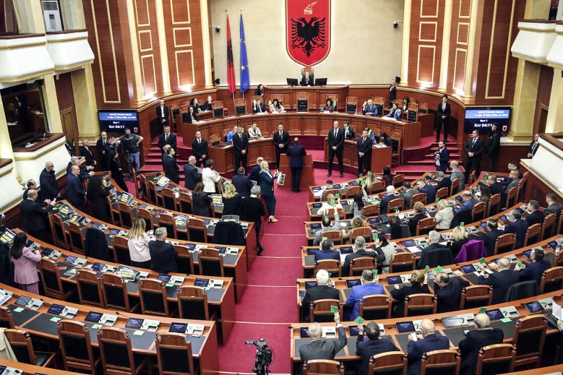 Les législateurs du Parti démocrate albanais, à gauche, regardent leurs collègues du parti socialiste au pouvoir voter à Tirana.