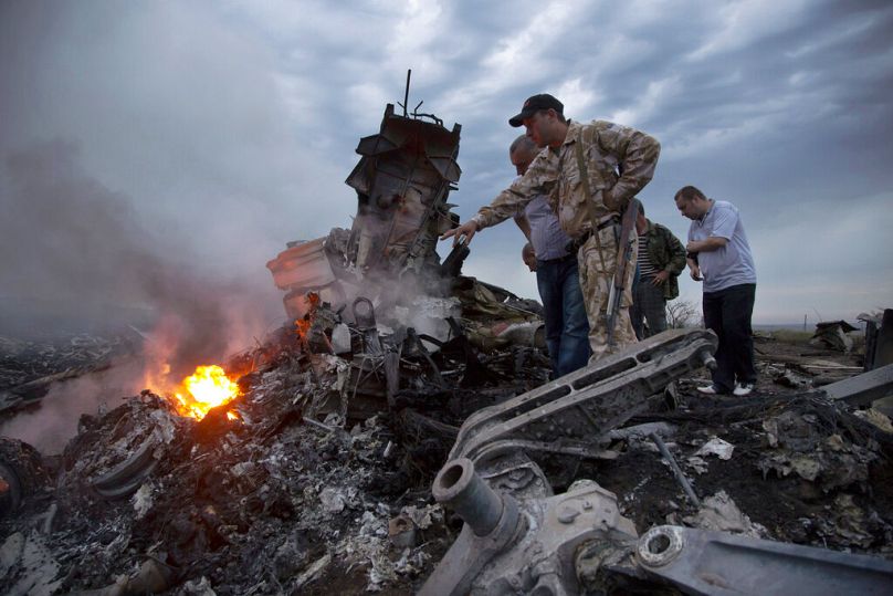Des personnes inspectent le site du crash du MH17 près du village de Hrabove, dans la région ukrainienne de Donetsk sous contrôle russe, 2014.