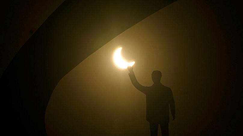 Une éclipse solaire vue derrière la statue de l'ancien président brésilien Juscelino Kubitschek, Brésil, 14 octobre 2023.