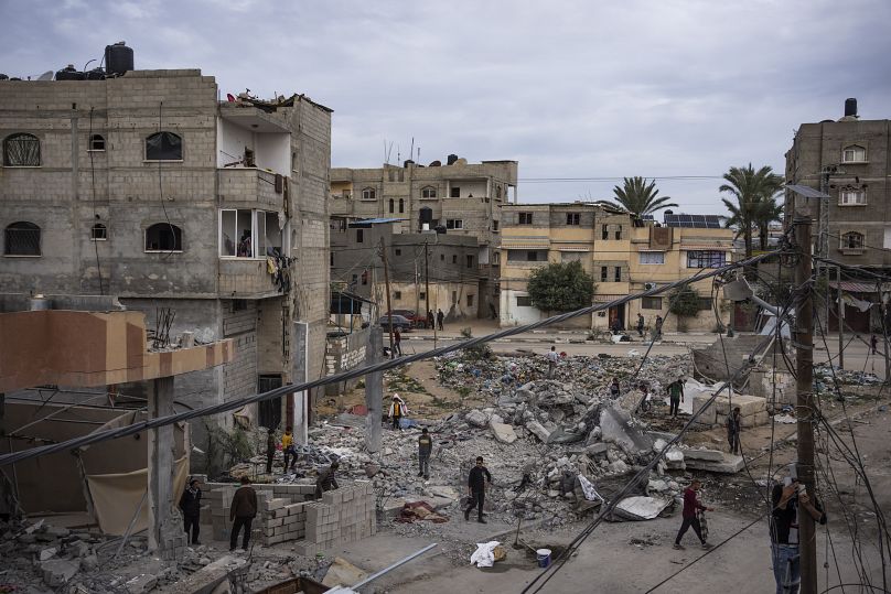 Des Palestiniens inspectent les décombres de la maison de la famille Hasouna, qui a été touchée par une frappe aérienne israélienne lors d'une opération de sauvetage de deux otages à Rafah, le 13 février 2024.