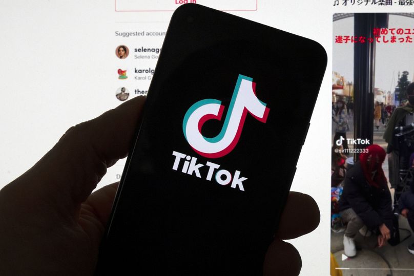 Le logo TikTok est visible sur un téléphone portable devant un écran d'ordinateur qui affiche l'écran d'accueil de TikTok, samedi 18 mars 2023, à Boston.