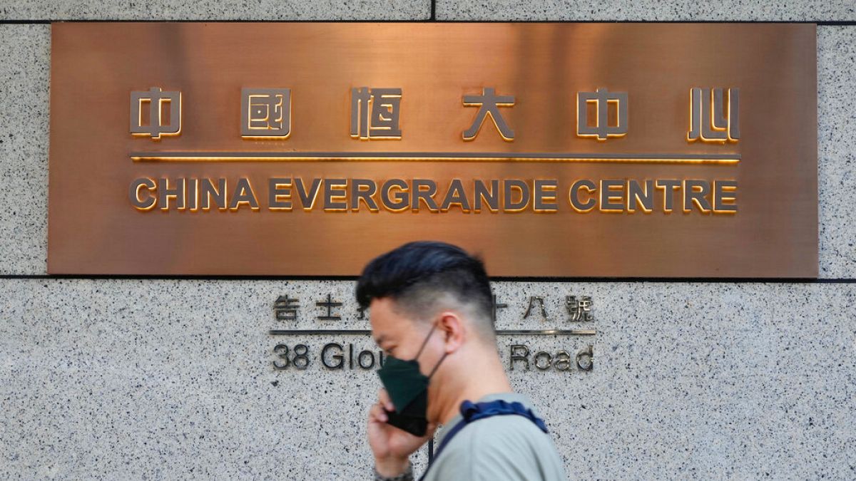 A man walks past the entrance of the headquarters of China Evergrande Group in Hong Kong Monday, Oct. 4, 2021.