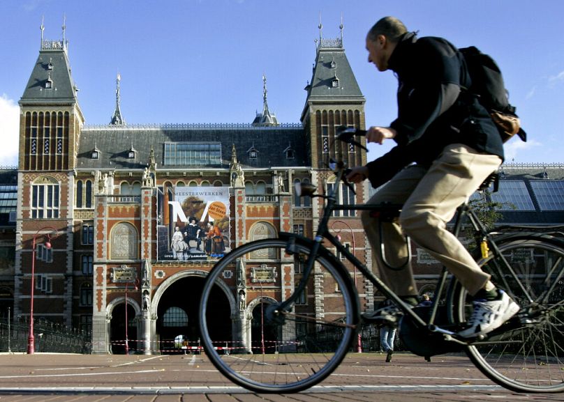Un cycliste passe devant le Rijksmuseum d'Amsterdam, octobre 2004