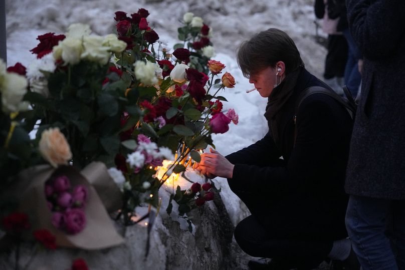 Des gens déposent des fleurs et des bougies pour rendre un dernier hommage à Alexei Navalny, dans une rue non loin du cimetière Borisovskoye à Moscou, en Russie, le vendredi 1er mars 2024.