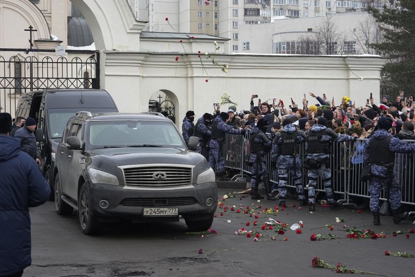 Les gens jettent des fleurs alors qu'une camionnette avec le cercueil du chef de l'opposition russe Alexei Navalny quitte l'église de l'icône de la Mère de Dieu Apaise mes chagrins, à Moscou.
