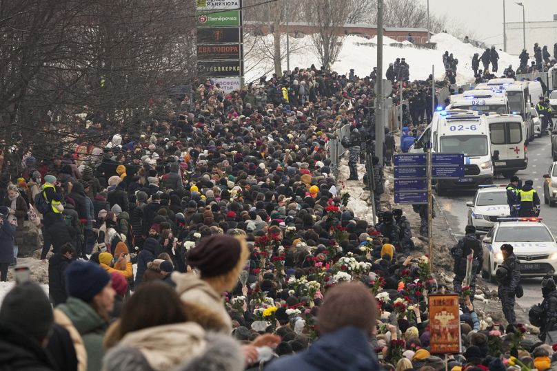 La police, à droite, observe les gens se diriger vers le cimetière Borisovskoye pour la cérémonie funéraire du chef de l'opposition russe Alexei Navalny, à Moscou, en Russie.