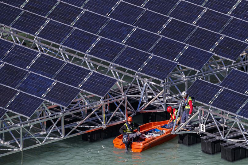 Des ouvriers assemblent des barges flottantes équipées de panneaux solaires sur le lac des Toules, un lac réservoir alpin, à Bourg-Saint-Pierre, octobre 2018