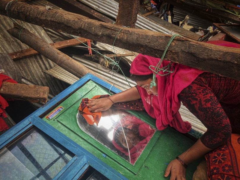 Une femme récupère les biens de sa maison endommagés par le cyclone Mocha sur l'île Saint-Martin à Cox's Bazar, au Bangladesh, en mai 2023.