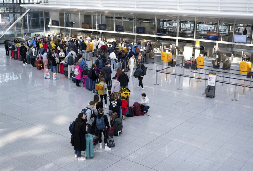 Des passagers attendent jeudi dernier au comptoir d'enregistrement de Lufthansa à l'aéroport de Munich, en Allemagne.
