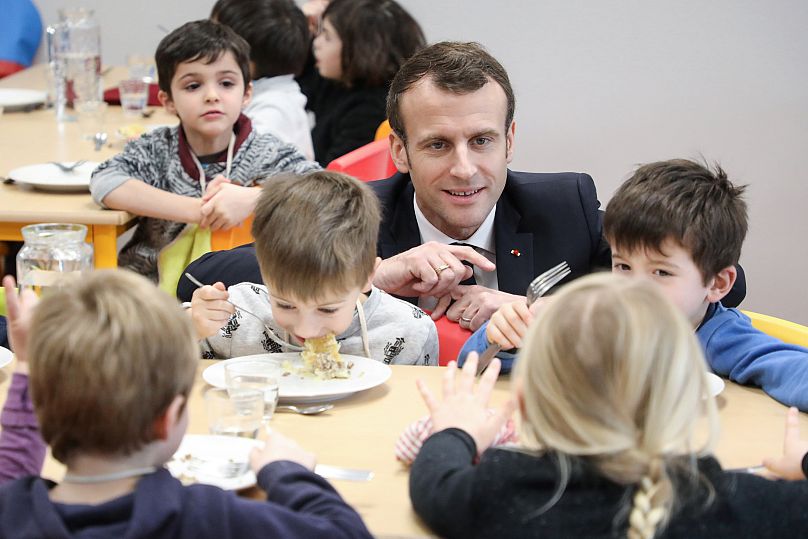 Le président français Emmanuel Macron rencontre des élèves lors de sa visite à la cantine scolaire de Saint-Sozy, dans le sud-ouest de la France