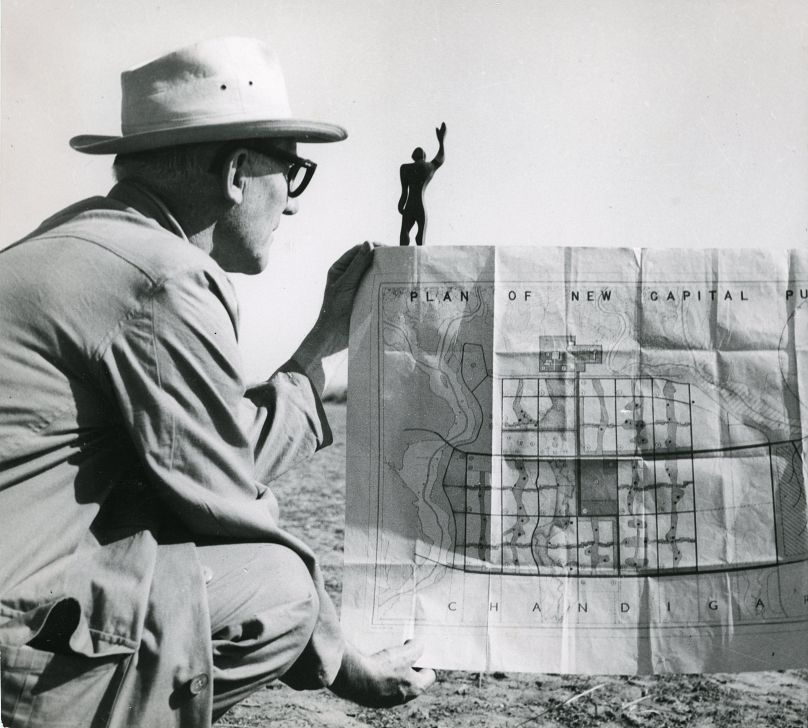 Le Corbusier à Chandigarh avec le plan de la ville et une maquette de l'Homme Modulaire, son système universel de proportions, 1951