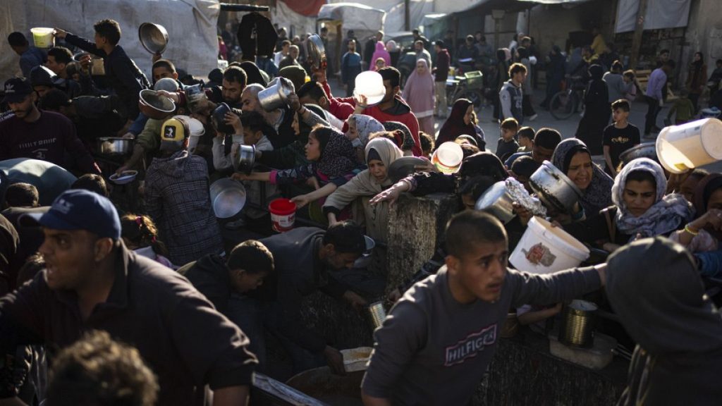 Palestinians line up for a free meal in Rafah, Gaza Strip, on Tuesday, March 12, 2024