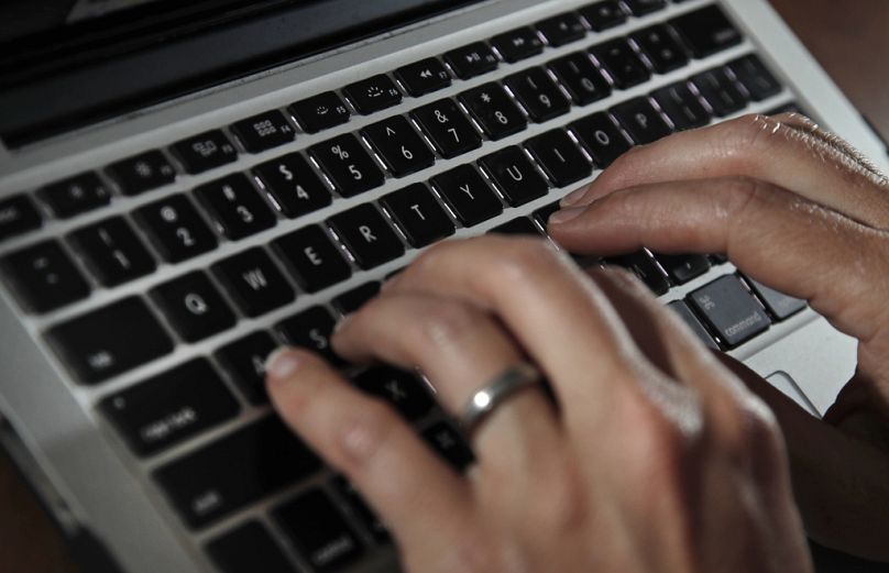 Une personne tape sur le clavier d'un ordinateur portable à North Andover, juin 2017