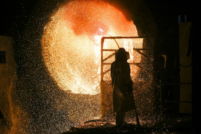 Un employé en tenue de protection travaille avec une poche de coulée d'acier dans une aciérie de Salzgitter, mars 2019.