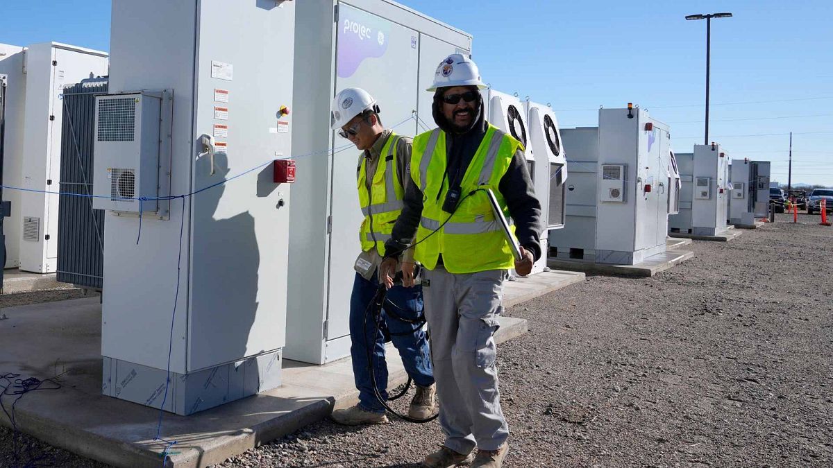 Workers walks the campus of battery storage pods at Orsted