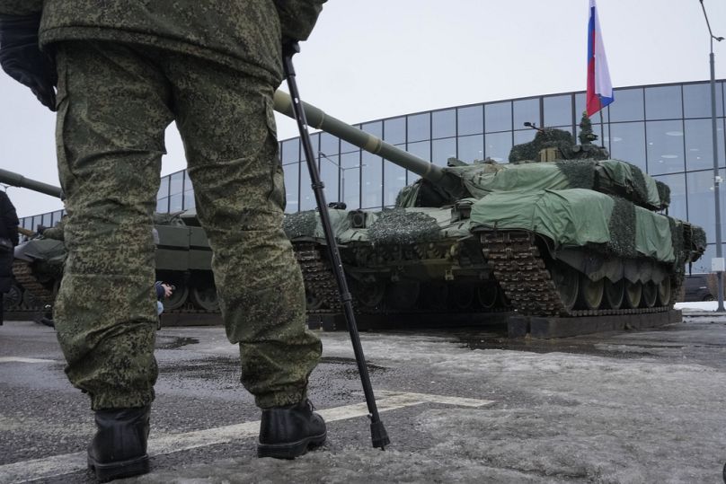 Un soldat russe se tient à côté d'un char T-90 lors d'une exposition d'armes lors du festival patriotique « Les Russes changent le monde » à Saint-Pétersbourg, en février 2024.