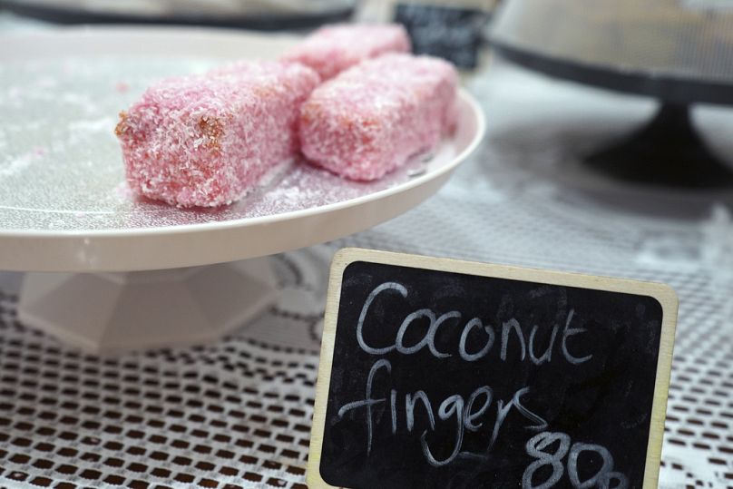 Des doigts de noix de coco, un dessert de célébration traditionnel composé d'une génoise glacée saupoudrée de noix de coco, sont exposés dans un restaurant de l'île.
