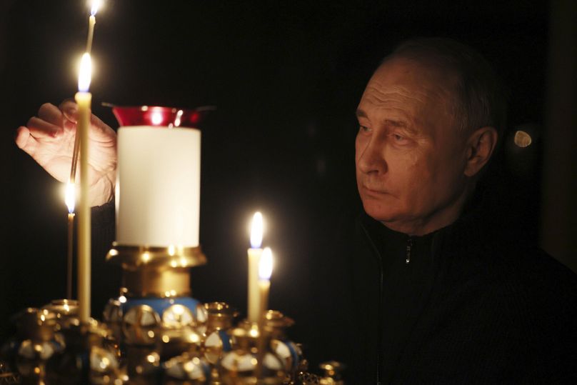 Poutine allume une bougie pour commémorer les victimes de l'attaque contre la salle de concert de l'hôtel de ville Crocus, le jour du deuil national, en Russie, le dimanche 24 mars 2024.