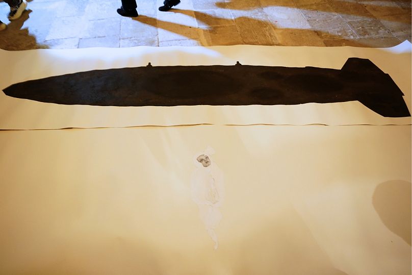 L'artiste américain Mel Chin a dévoilé un ajout surprise à son œuvre de la Biennale, une comparaison côte à côte d'une victime palestinienne de 5 mois et d'une bombe MK-84 de fabrication américaine.